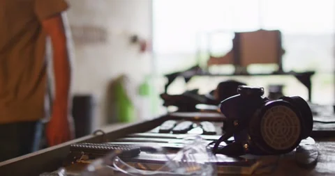 Midsection of caucasian male blacksmith walking in workshop with tools on table Stock Footage 340453921