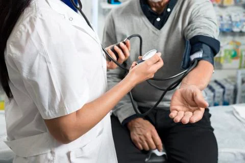 Midsection Of Chemist Checking Patient's Blood Pressure Foto stock