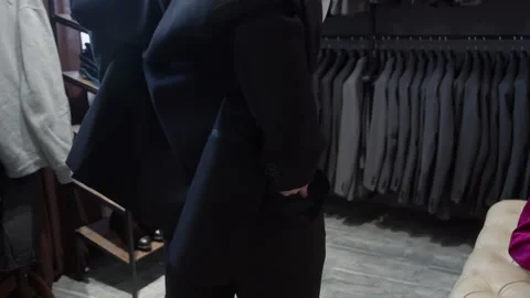 Midsection of customer trying on new trousers at clothing shop Stock Footage 297471310