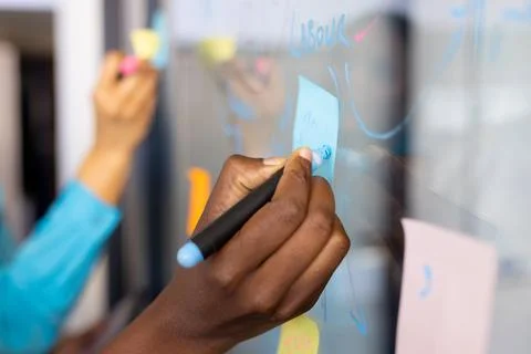 Midsection of diverse business people using glass board and brainstorming at Stock-Fotos
