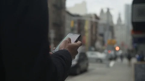 Midsection dolly shot of man using smart phone while walking in city Vídeos de archivo 77797601