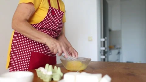 Midsection of elderly woman stirring eggs with hand mixer Stock Footage 280314227