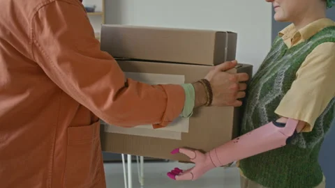 Midsection of Girl with Bionic Arm Giving Boxes to Unrecognisable Boyfriend 스톡 동영상 323300788