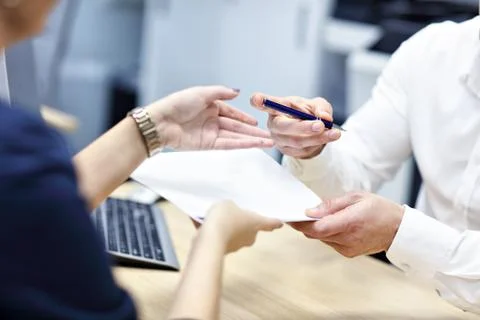 Midsection of hands holding documents and pen Stock Photos