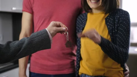 Midsection of happy couple shaking new house key Stock Footage 86137839