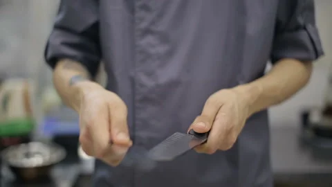Midsection of male chef sharpening knife in commercial kitchen Video stock 92125768