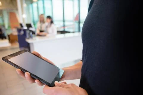 Midsection Of Male Passenger Using Digital Tablet At Airport 写真素材
