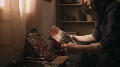 Midsection of Man Choosing Vinyl Record and Putting it on Record Player Stock Footage 338069636