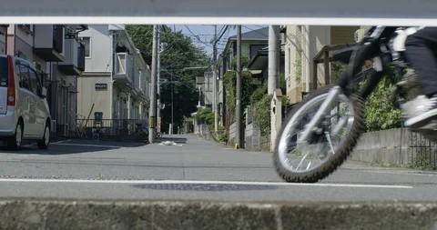 Midsection of man driving motorcycle on road in town in slow motion, Japan Stock Footage 124712249
