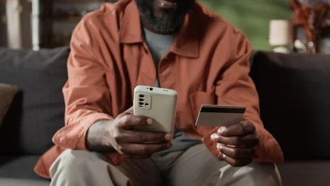 Midsection of Man Making Online Payment with Credit Card on Smartphone Stock Footage 345143412