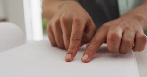 Midsection of man sitting at table in kitchen reading braille Stock Footage 341466731