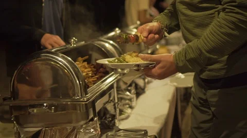 Midsection of man taking food from container on table at illuminated campsite - Stock Footage 129206650
