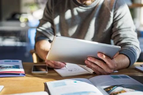 Midsection of man using tablet computer while studying at table in classroom Stock Photos