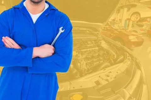 Midsection of mechanic holding spanner Stock Photos
