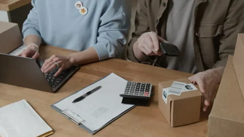 Midsection of Two Coworkers Registering Parcels with Laptop and Barcode Scanner Stock Footage 306287893