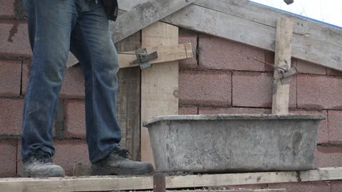 Midsection of unknown man hold shovel putting cement concrete on the building Stock Footage 220809114