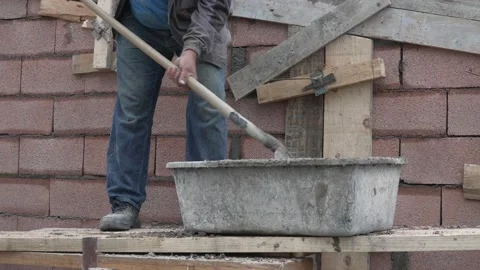 Midsection of unknown man hold shovel putting cement concrete on the building Stock Footage 220809322
