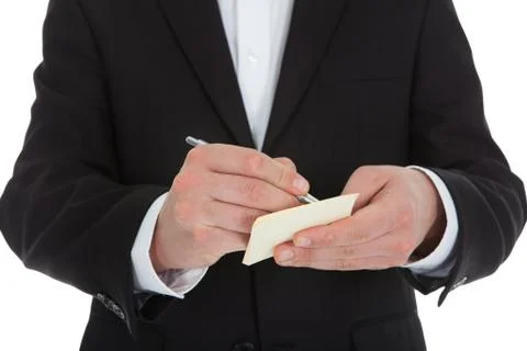 Midsection of waiter writing on notepad isolated over white background Foto stock