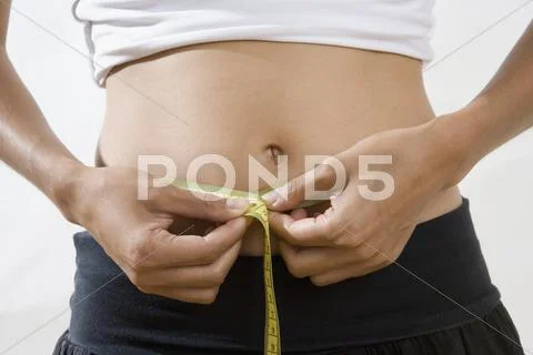 Midsection of a woman measuring her waist Stock Photos