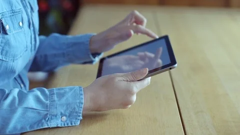 Midsection of woman scrolling digital tablet online at table Stock Footage 70175004