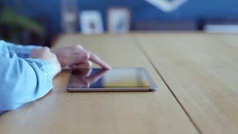Midsection of woman scrolling digital tablet online at table Stock Footage 70175254