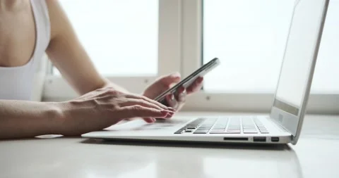 Midsection of woman using mobile phone and laptop on desk Stock-Footage 152870938