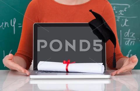 Midsection of young college student showing laptop with mortarboard and degre Stock Photos