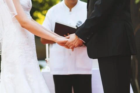 The midsection of young couple hold hand at wedding ceremony 스톡 사진