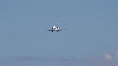 Midsize business jet flying final approach into generic airport heat haze Stock Footage 265471766