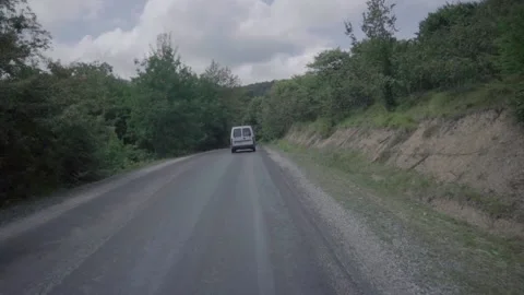 Midsize car driving to its destination alone on a green mountainous terrain. Stock Footage 146716175