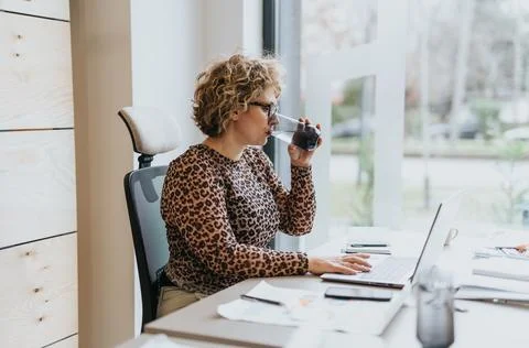 In the midst of a challenging work shift, a senior female employee rejuvenates Stock Photos