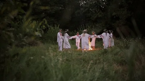 Midsummer. Young people in Slavic clothes revolve around a fire in the Midsummer Stock Footage 70676231