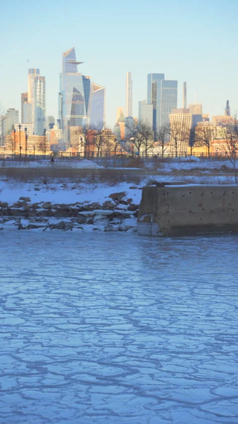 Midtown Manhattan skyscraper stands beyond frozen Hudson River from New Jersey Vídeo Stock 336630421