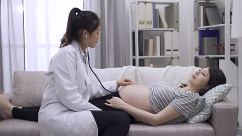 Midwife using stethoscope to listen bare belly Video stock 133696459