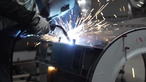 MIG welding with bright sparks flying on washing machine drum component in Stock Footage 334965510