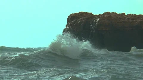Mighty and high waves hit the rocky coast, taken in slow motion. Stock Footage
