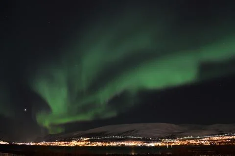 Mighty northern light dancing over snowy mountain peak in northern norway o.. Foto stock