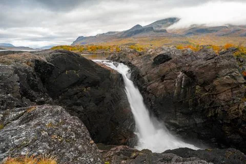 Mighty scenic waterfall under dramatic sky. Stuor Muorkke waterfall in Stora Stock Photos