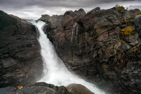 Mighty scenic waterfall under dramatic sky. Stuor Muorkke waterfall in Stora Stock Photos