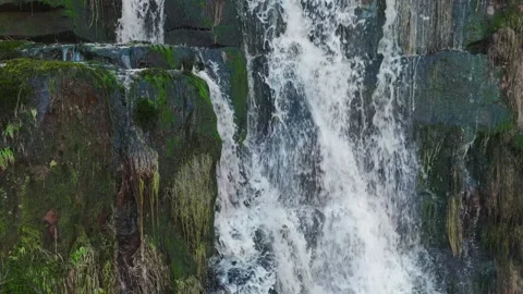 Mighty water crashes over mossy, rugged rocks 库存影片 342935973