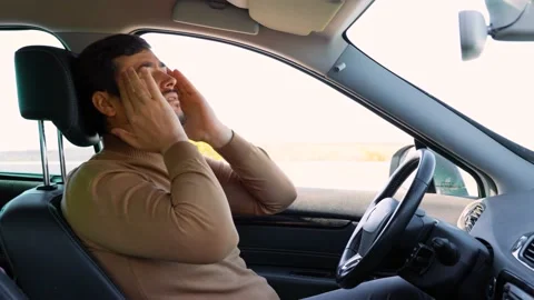 A migraine like headache torments the driver behind the wheel, holds his head Stock Footage 221756723