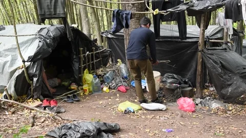 Migrants are trying to light a fire in a wild camp in the forest. Stock Footage 146369177