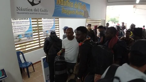 Migrants make a line at the bus terminal to buy tickets Stock Footage 113523882
