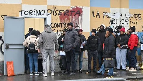 Migrants queue outside the immigration office in Turin, Italy - 23 Jan 2025 Stock Photos