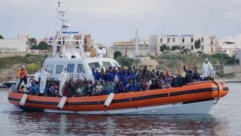 Migrants on a rescue boat chanting while landing in Lampedusa Stock Footage 108513442