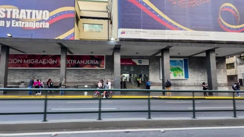 Migration crisis. SAIME building Downtown Caracas. Queue People wait outside to Stock Footage 308453246
