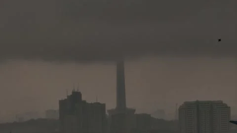Milad Tower hidden by dark storm clouds with birds in flight Stock Footage 317909981