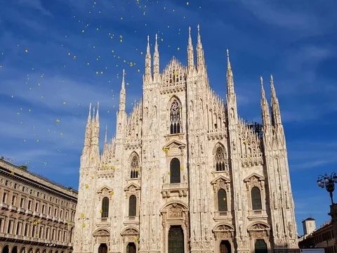 Milan cathedral square with a blue sky and yellow balloons fly away Stock Footage 81003439