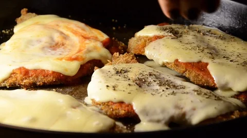 Milanesa Napolitana being prepared with oregano -  traditional Argentina meal Stock Footage