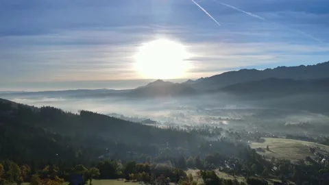 Mild sunshine sun rays emerging through the morning clouds fog. Stock Footage 163427481